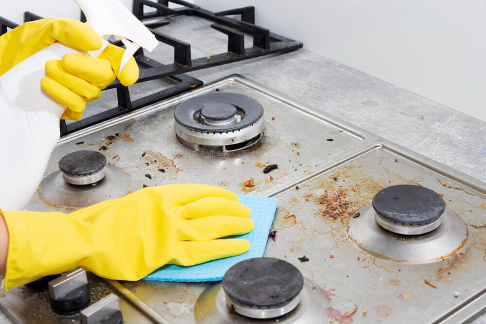 Cleaning-a-gas-stove-with-kitchen-utensils