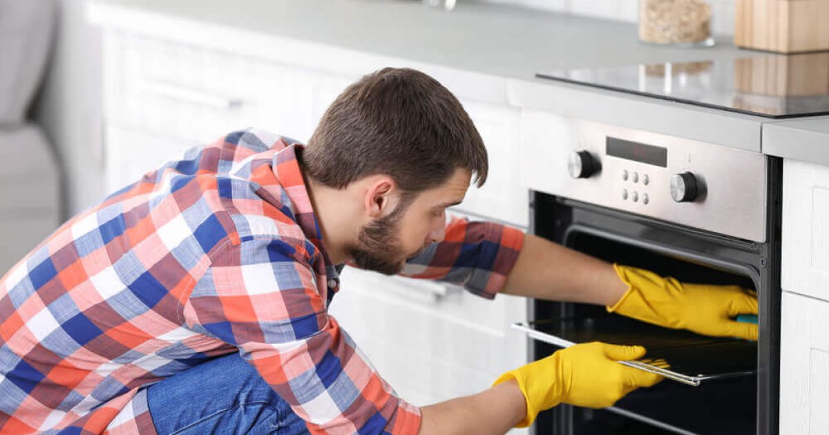 man-cleaning-oven-in-kitchen